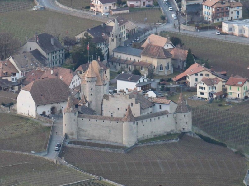 Le château d'Aigle vu d'avion avec la maison de la Dime directement à sa gauche et l'église du Cloître en arrière-plan Le château d'Aigle vu d'avion avec la maison de la Dime directement à sa gauche et l'église du Cloître en arrière-plan