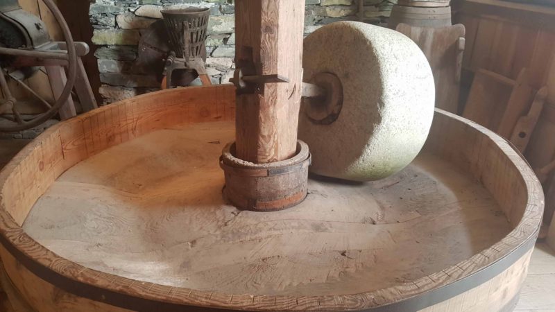 Une meule en pierre chargée d'écraser les grains aux moulins de la Tine.