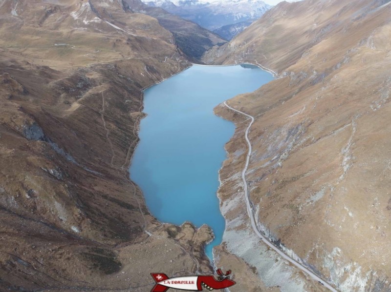 Vue aérienne du lac formé par le barrage de Moiry avec la route et le sentier pour faire le tour du lac. Barrage de Moiry, Val d'Anniviers. 
