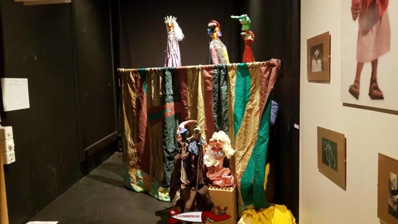 Le théâtre avec des enfants cachés derrière le rideau en train de manipuler de marionettes.