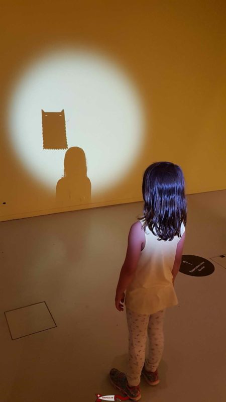 un enfant devant un atelier de l'exposition "Dans la tête" du musée de la main