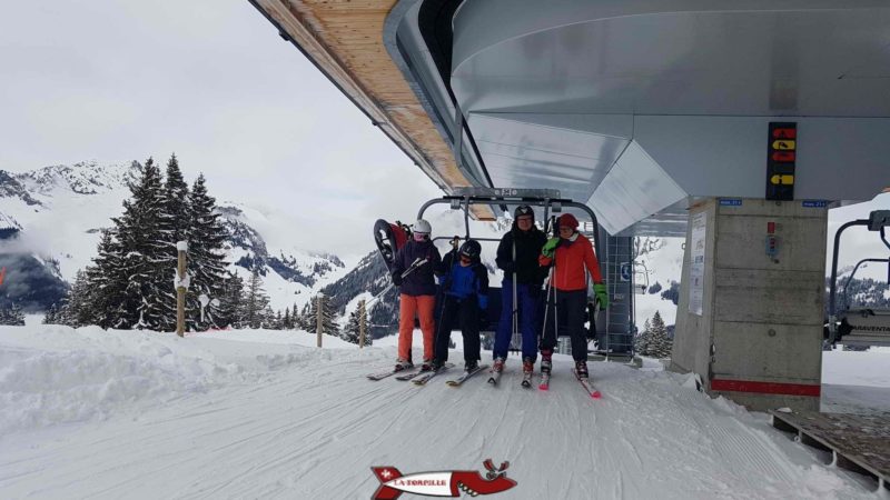 Des skieurs sortant au sommet du télésiège.