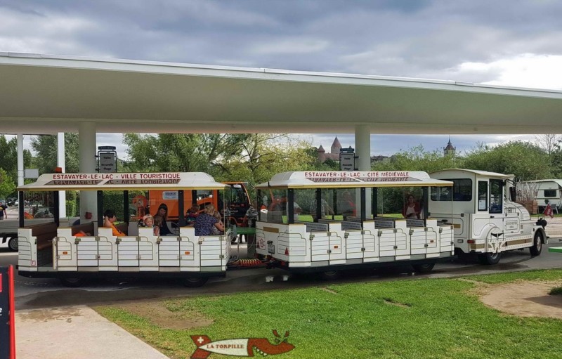 Un arrêt du petit train d'Estavayer se trouve au milieu du grand bâtiment, à l'entrée de la plage.