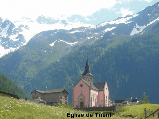 La jolie église rose de Trient avec le glacier du Trient en arrière-plan
