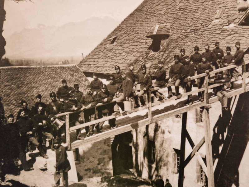 Des soldats de l'armée suisse aux environs du début du 20e siècle quand le château servait de caserne. Un pont en bois permettait d'atteindre les combles du château.