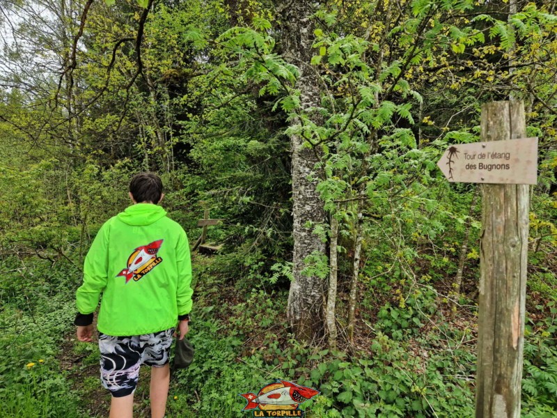 Un panneau indiquant la direction pour faire le tour du lac. Étang des Bugnons