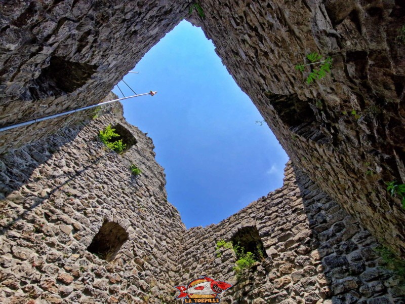 La vue depuis l'intérieur du donjon au sommet duquel flotte le drapeau de la commune de Châtel/Montsalvens.