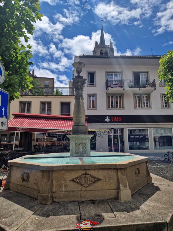 La fontaine de la Grand-Rue avec le clocher de la collégiale.