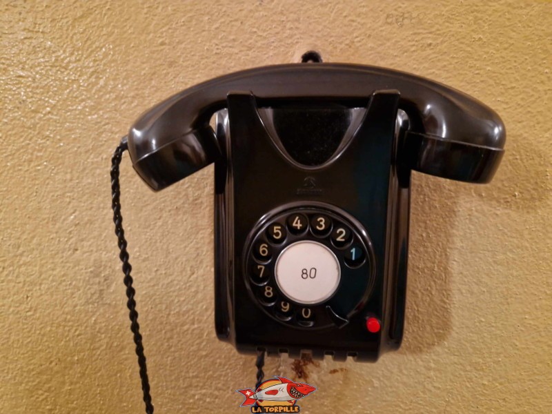 Un ancien téléphone accroché à un mur.