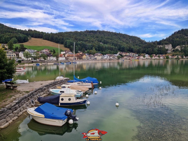 Des bâteaux amarrés juste avant le canal. En arrière-plan, le village du Pont.