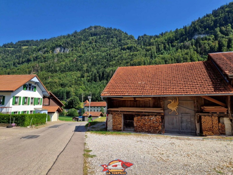 Une ferme avec l'emblème de la grue, symbole de la Gruyère.