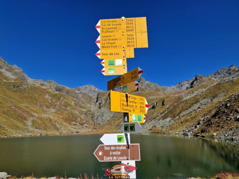 Un panneau indicateur au niveau du lac de Louvie. 4 h 10 de marche sont nécessaires pour atteindre le Mont-Fort, point culminant du fameux domaine skiable Verbier - 4 Vallées à 3329 mètres d'altitude.