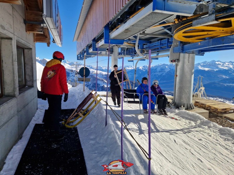 Le personnel retire les luges accrochées aux sièges. Piste de luge d'hiver des Rousses, domaine skiable d'Anzère, Ayent.