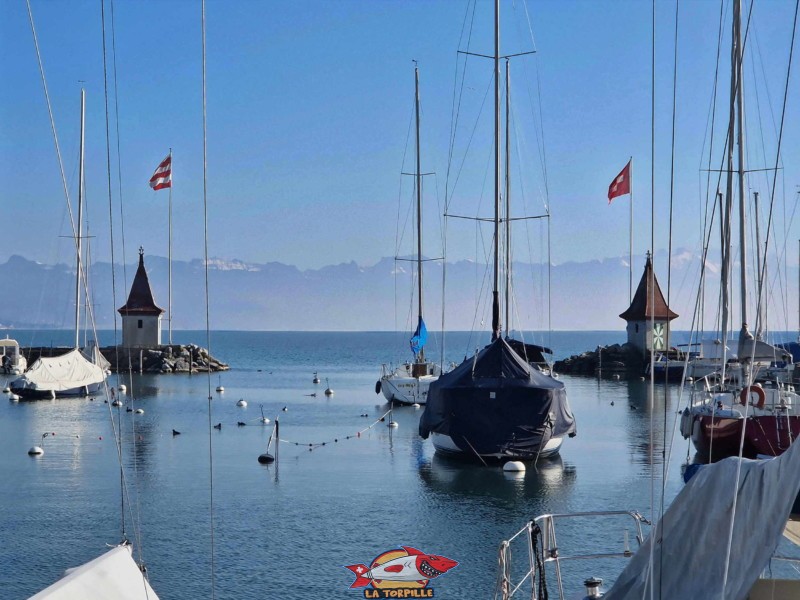 Deux tourelles marquent l'entrée du port. À gauche, le drapeau de Morges, et, à droite, celui de la Suisse.