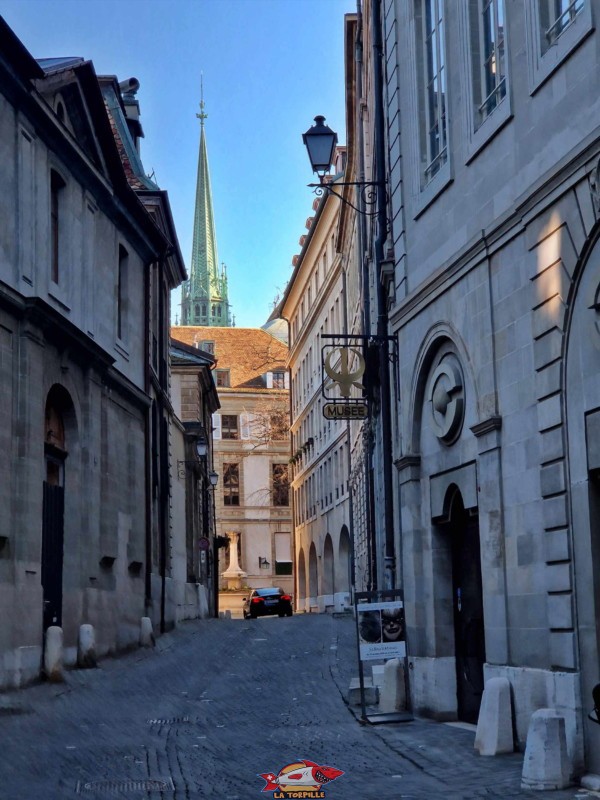 La rue Jean-Calvin avec, en arrière-plan, la flèche ajoutée en 1895 à la cathédrale St-Pierre. Sur la droite, l'entrée du musée Barbier-Mueller. Genève