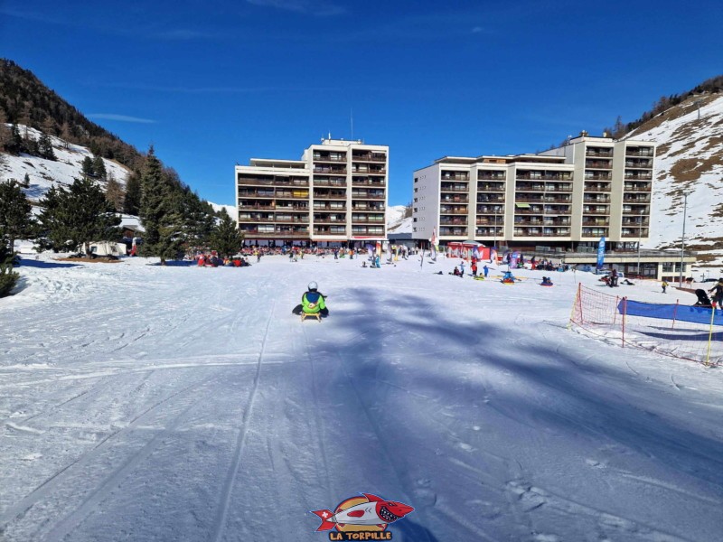 La dernière descente et le passage à côté des blocs d'immeuble de Siviez. Piste de luge de Tortin - Siviez, val de Nendaz.