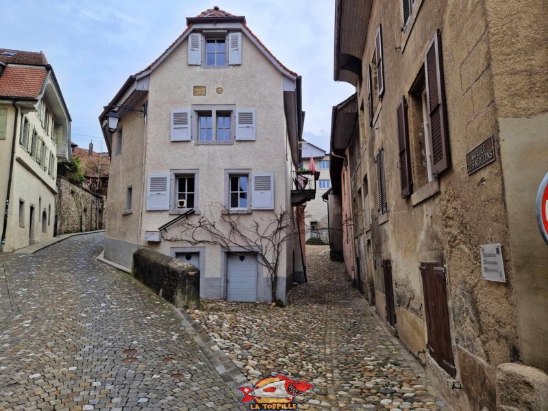 La vue depuis le bas de la ruelle des Moulins (droite) au niveau de la chapelle de Rivaz. Sur la gauche, la Grand-Rue.