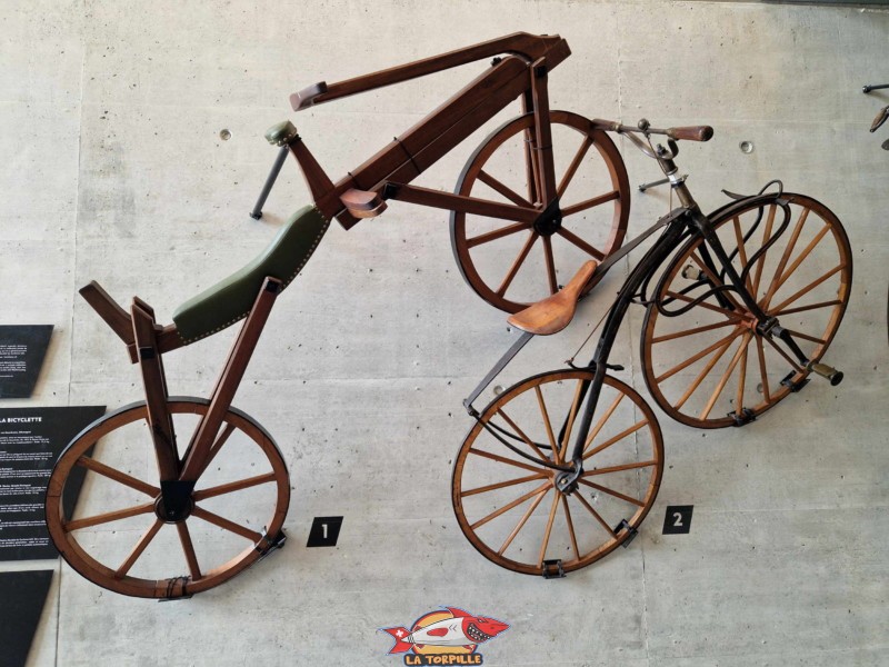 À gauche, la draisienne, ancêtre du vélo. C'est le premier véhicule à deux roues à propulsion humaine. À droite, un vélocipède à pédales, années 1860, C'est le début de la propulsion à l'aide de pédales. Centre mondial du Cyclisme (CMC) de l'UCI (Union Cycliste international) à Aigle, canton de Vaud.