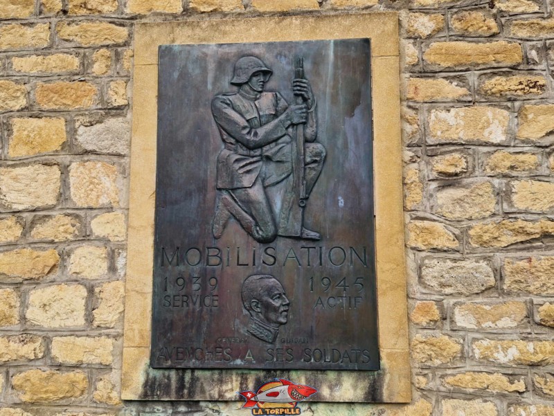 Une plaque commémorative sur la façade d'entrée de l'église Ste-Madelaine en mémoire de la mobilisation des soldats de 1939 à 1945. Sur le bas, la tête du général Guisan. Ville médiévale d'Avenches, vieille ville, région de la Broye, canton de Vaud.