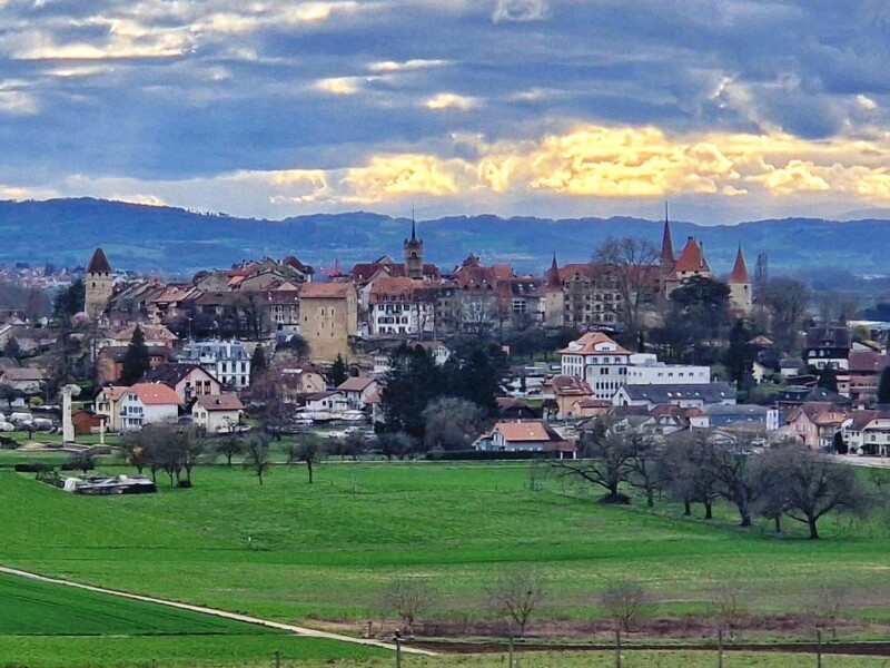 La vue depuis la porte romaine de l'Est. De gauche à droite, la tour de Benneville, la tour de l'Évêque, le clocher de l'église Ste-Marie-Madelaine et le château. Ville médiévale d'Avenches, vieille ville, région de la Broye, canton de Vaud.