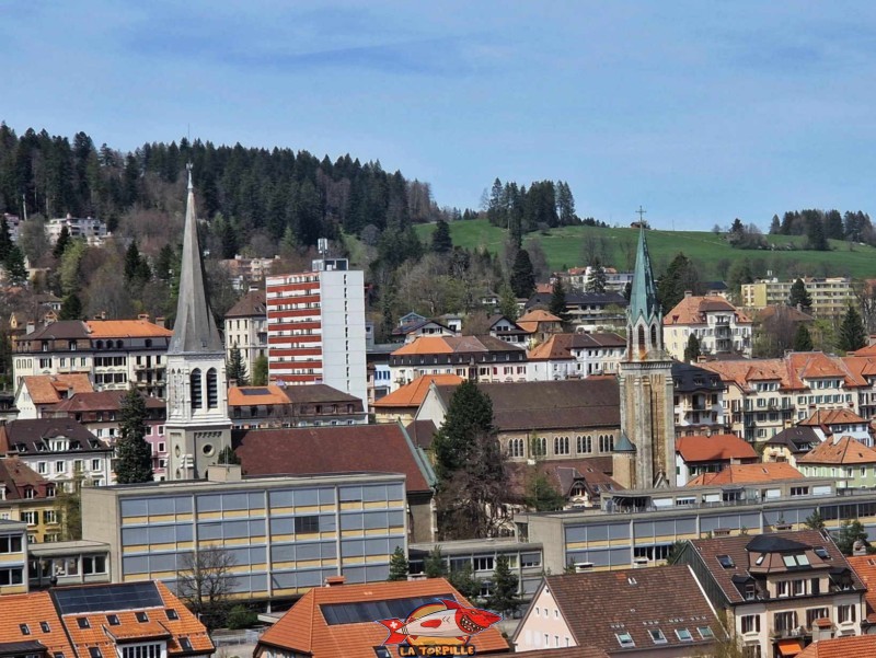  Terrasse panoramique, zone est. Zoom direction nord. À gauche, l'église protestante du Temple Farel. À droite, l'église catholique romaine du Sacré-Coeur. Tour Espacité, La Chaux-de-Fonds, Canton de Neuchâtel.