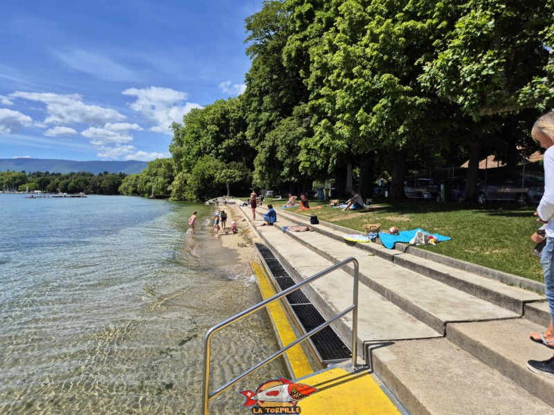 Des escaliers permettent d'accéder au lac et une étroite bande de sable. zone route. Plage de Promenthoux, Prangins, Léman.