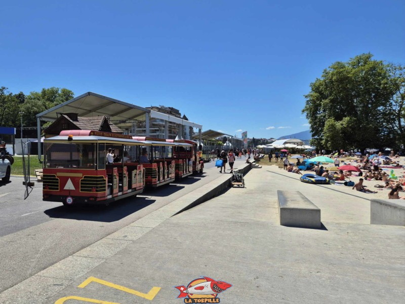Le petit train de la rive gauche de la rade de Genève. Sur la droite, Baby-Plage. Le petit train de la rive gauche de la rade de Genève. Sur la droite, Baby-Plage.