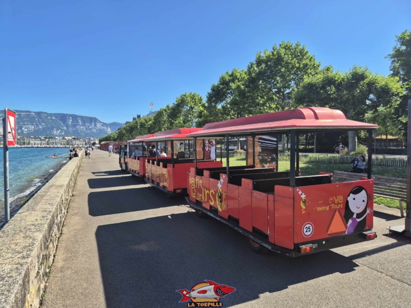 Le petit train au Quai Wilson avec, en arrière-plan, la ville de Genève et le Salève.