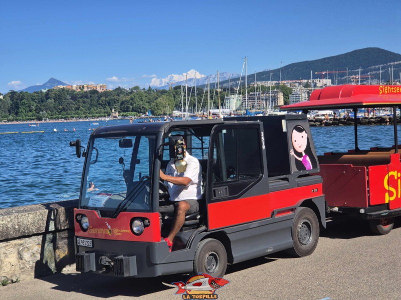 Le petit train du Geneva Sightseeing Tour sur le quai Wilson avec le Mont Blanc en arrière-plan.