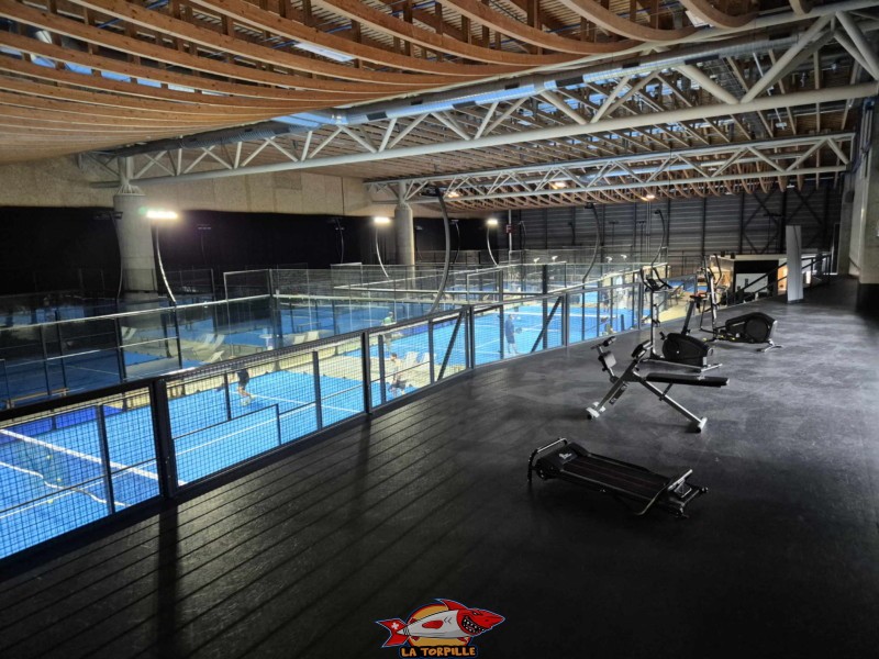 La mezzanine au-dessus des gradins avec les machines de musculation. Padel Parc Fribourg, Granges-Paccot.
