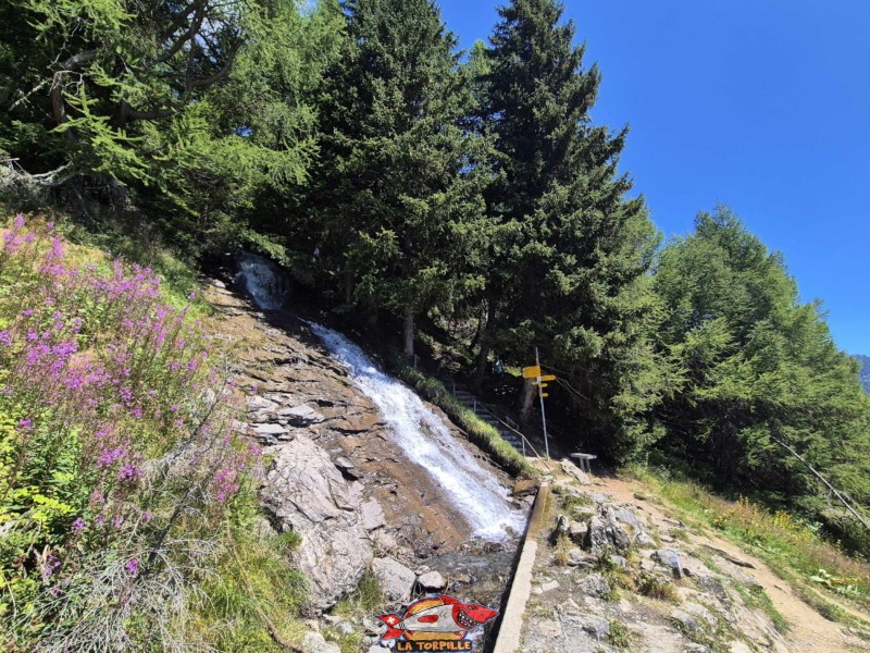 Le bisse qui forme une cascade au-dessus de la cave du Scex. Randonnée au bisse du Tsittoret, Crans-Montana, Valais central.