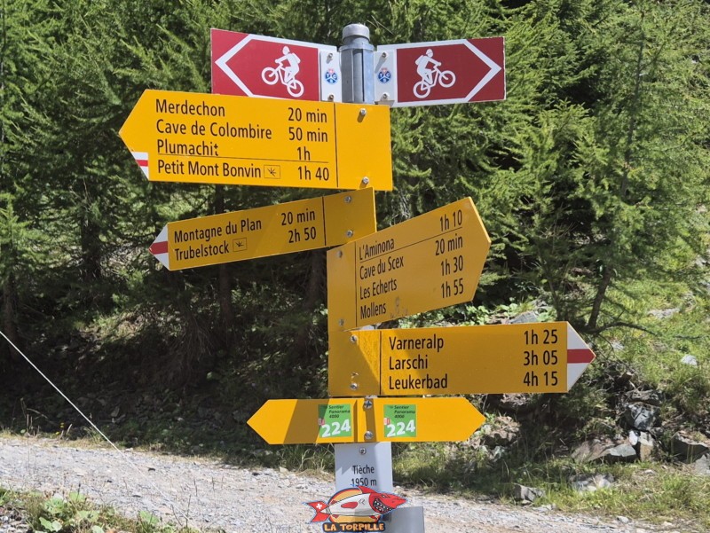 Un panneau indicateur à la prise d'eau. Le Petit Mon Bonvin (1 h 40 min), Aminona (1 h 10 min), Cave du Scex (20 min), Mollens (1 h 55 min), Loèche-les-Bains (4 h 15 min). Randonnée au bisse du Tsittoret, Crans-Montana, Valais central.