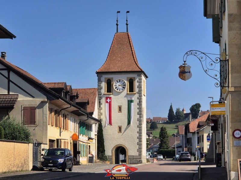 La très belle Tour de l'Horloge dans la ville de Cudrefin. En arrière-plan, à droite, l'église St-Théodule.