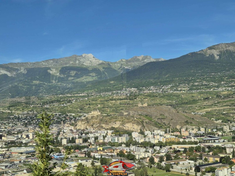 La vue depuis le cas postal au début de la montée du val d'Hérens. La ville de Sion et ses deux fameuses collines : Valère et Tourbillon. La vue depuis le cas postal au début de la montée du val d'Hérens. La ville de Sion et ses deux fameuses collines : Valère et Tourbillon. Gorges de la Borgne - Val d'Hérens