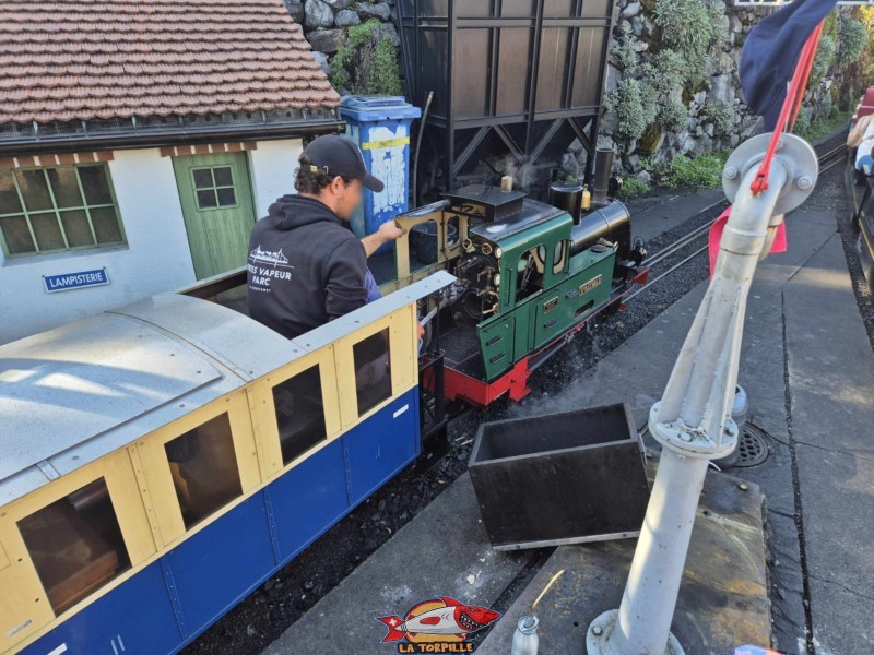 Un mécanicien en train de mettre du charbon dans une locomotive à vapeur. Swiss Vapeur Parc, Le Bouveret, canton du Valais. Trains miniatures. Un mécanicien en train de mettre du charbon dans une locomotive à vapeur. Swiss Vapeur Parc, Le Bouveret, canton du Valais. Trains miniatures.