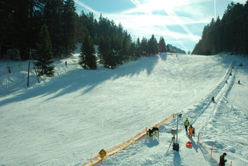 La piste de luge sur la droite et la piste de ski sur la gauche