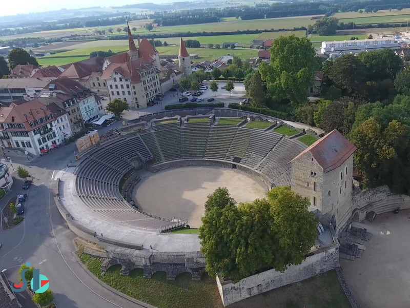 L'amphithéâtre depuis un drone. En arrière-plan, le château médiéval d'Avenches. Photo : Youtube Panorama JL, Amphithéâtre. Ruines Romaines d'Avenches, canton de Vaud.