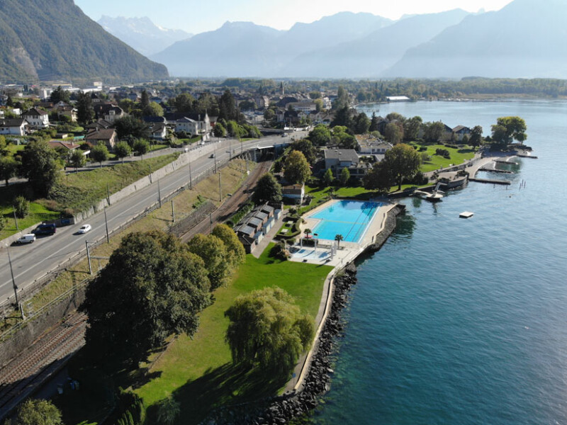La vue d'ensemble de la piscine avec la zone herbeuse au premier plan. La vue d'ensemble de la piscine avec la zone herbeuse au premier plan.
