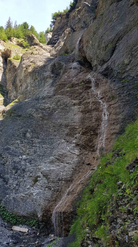 Une chute d'eau le long de la paroi rocheuse.