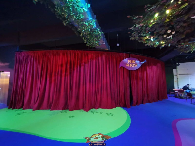 Un théâtre avec des gradins qui permet aux enfants d'assister à des représentations comme des tours de magie.