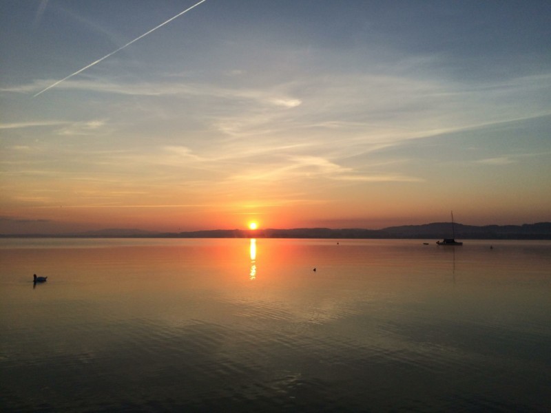 Le lever du soleil au-dessus des eaux du lac de Morat.