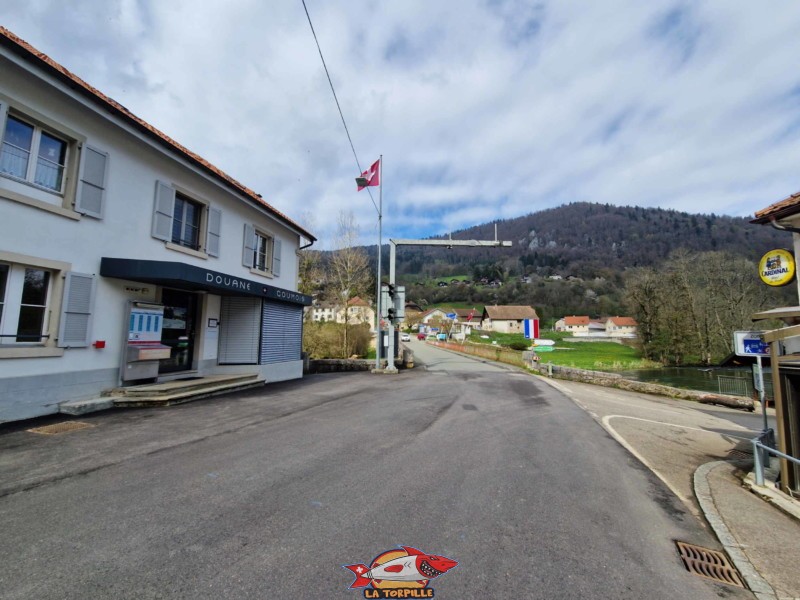 L'ancien poste frontière de Goumois Suisse avant le pont sur le Doubs pour rejoindre Goumois en France. Sur la droite, la petite route venant au parking de la balade de la cascade.