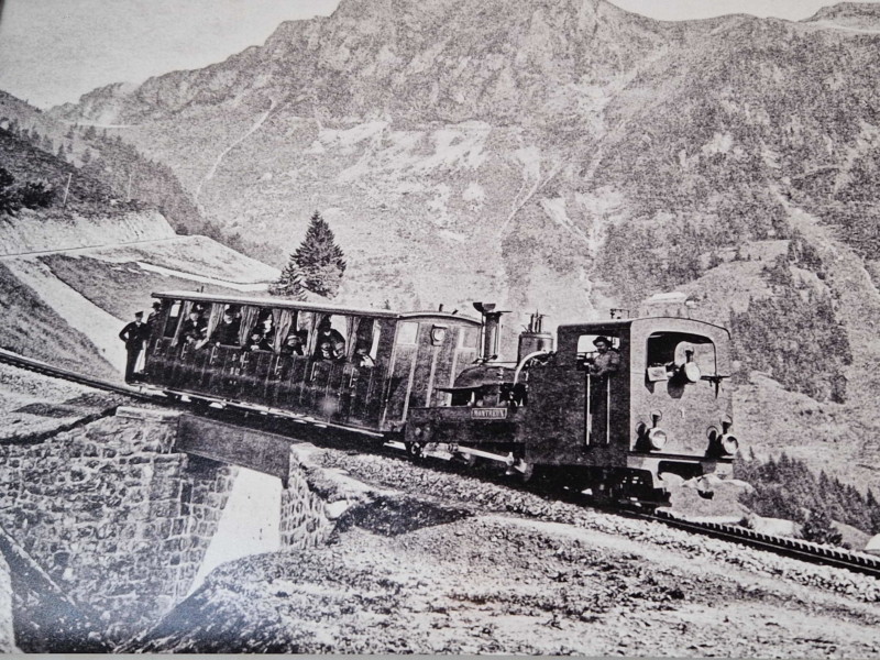 Une locomotive à vapeur pousse un wagon au-dessus de Caux.