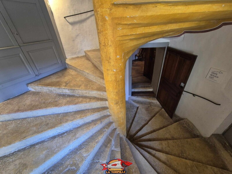 On monte l'escalier en colimaçon du rez-de-chaussée au 1ᵉʳ étage. Château de La Sarraz, canton de Vaud.