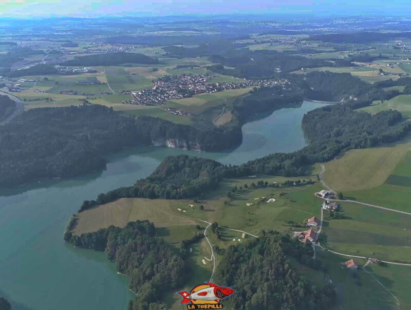 Le barrage avec le village de Rossens sur la gauche. Ce dernier fait partie de la commune de Gibloux. L'étendue d'eau serpente au-dessus d'anciennes et magnifiques gorges formées par la Sarine et bien connues par les anciens de la région.