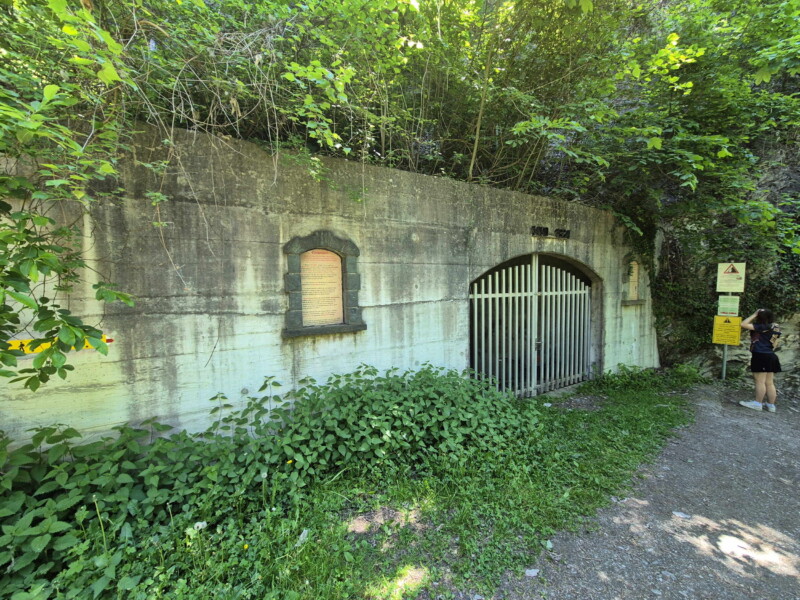 La structure en béton qui marque le début du tunnel du Châtelard. Complètement à droite, le chemin du bisse. La structure en béton qui marque le début du tunnel du Châtelard. Complètement à droite, le chemin du bisse. Grand bisse de Lens, Valais central.