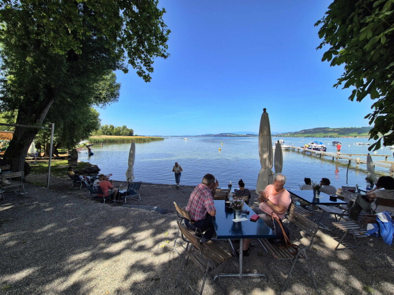 La plage et la buvette du camping. La plage est connue pour ses couchers de soleil sur le lac de Morat. Plage du Camping Muntelier, région Morat.