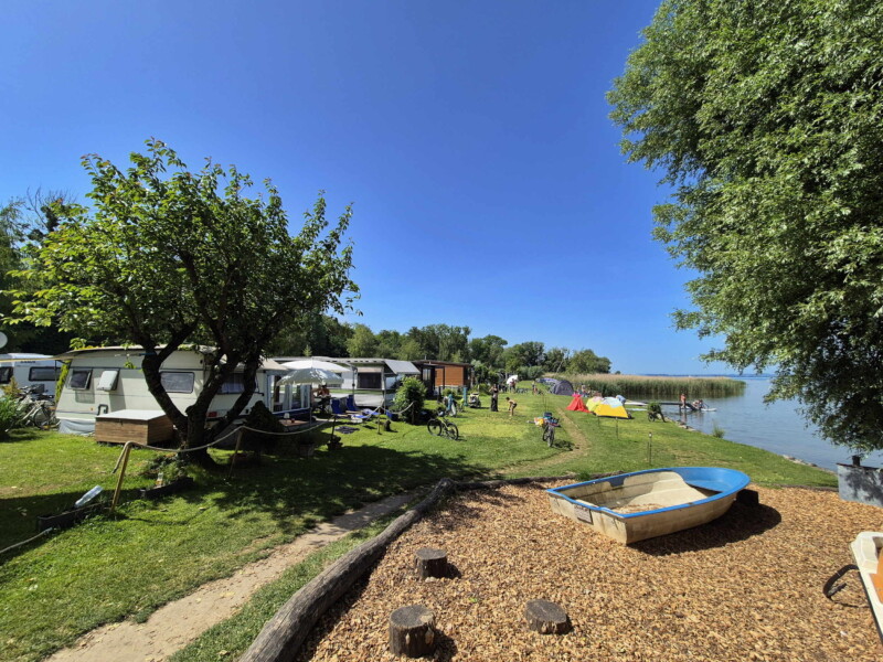 La petite zone de pelouse et les enrochements. Plage du Camping Muntelier, région Morat.