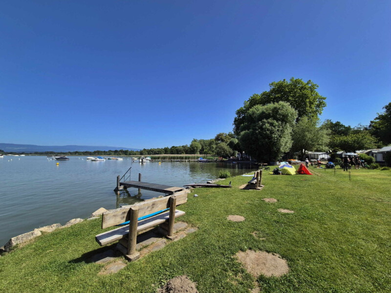 La petite zone de pelouse et les enrochements. Plage du Camping Muntelier, région Morat.