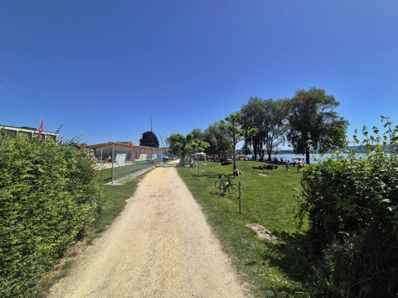 La route en graviers le long du lac, au nord de la plage. Plage de Nant, Mont-Vully, Lac de Morat, Canton de Fribourg.